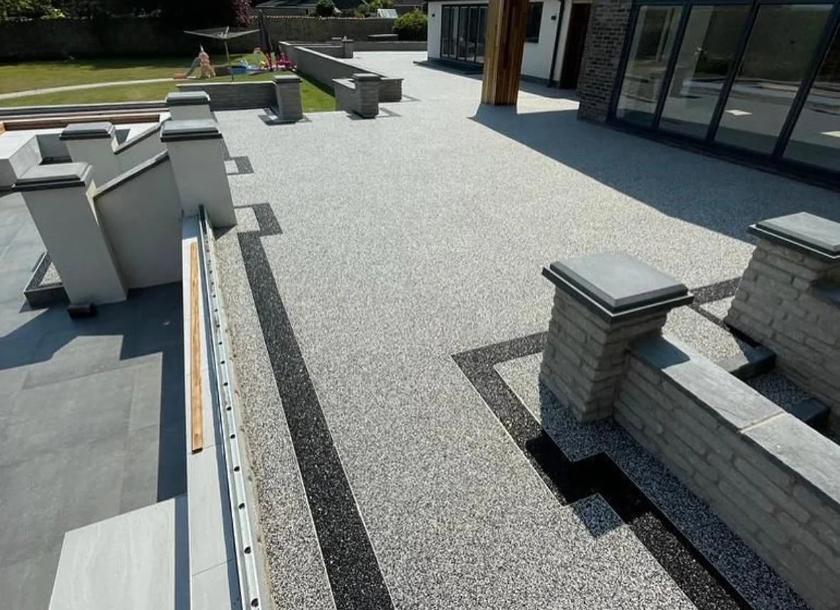Silver resin garden terrace with dark borders and steps beside seating